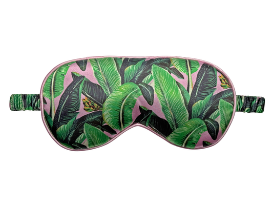 Front view of a satin eye mask with a green banana leaf print.