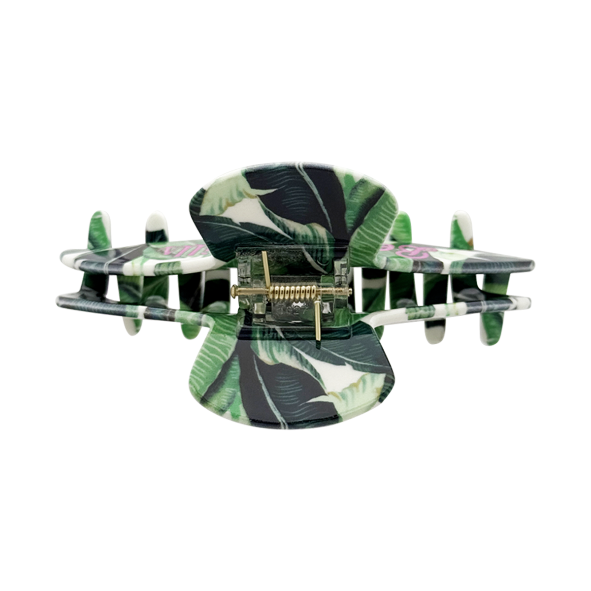 Top view of a claw clip with a green banana-leaf pattern and a visible gold spring mechanism on a white background.