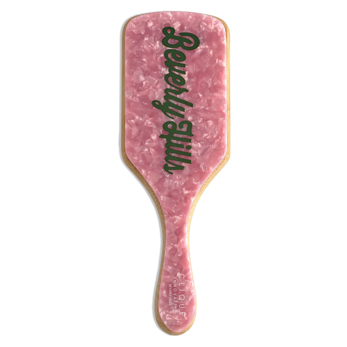 Top view of a pink marble paddle hairbrush with ‘Beverly Hills’ written in green script across the back.