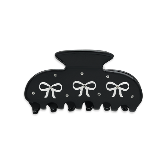 Front view of a black claw clip with three white bow graphics and silver rhinestones on a white background.