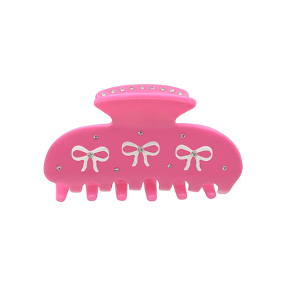 Front view of a hot pink claw clip with three white bow graphics and silver rhinestones on a white background.