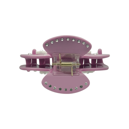 Top view of a mauve claw clip showing silver rhinestones along the top edges, a gold spring mechanism, and side views of white bow graphics on a white background.