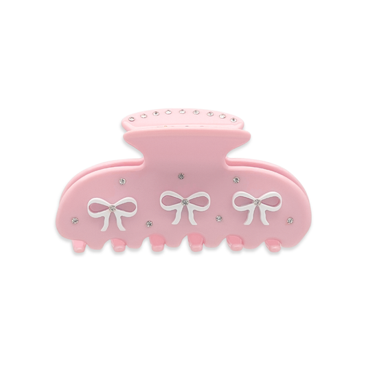 Front view of a light pink claw clip with three white bow graphics and silver rhinestones on a white background.