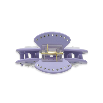 Top view of a light purple claw clip with silver rhinestones outlining the top edges and a visible gold spring mechanism on a white background.
