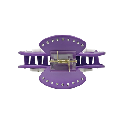 Top view of a violet claw clip with silver rhinestones along the top edges and a visible gold spring mechanism on a white background.