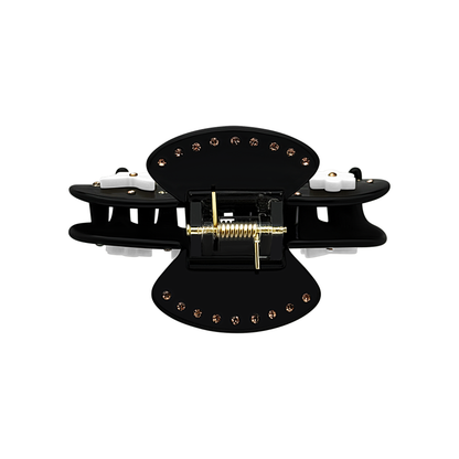 Top view of a black butterfly claw clip showing the spring and decorative details.