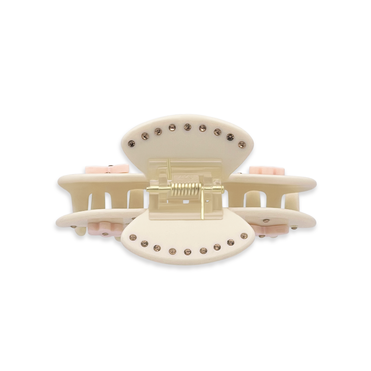 Top view of a beige claw clip showing gold rhinestones along the top edges, a gold spring mechanism, and side views of light pink flower and butterfly graphics on a white background.
