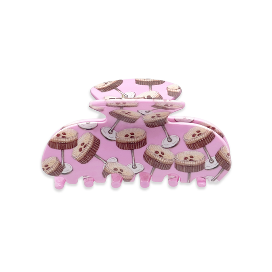 Front view of a pink claw clip with repeating espresso martini illustrations on a white background.