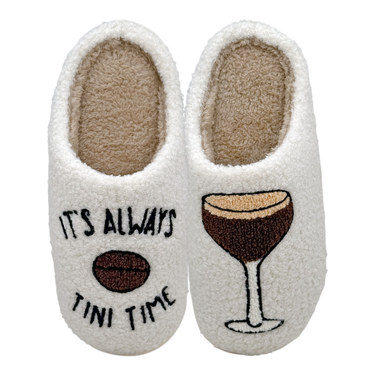White slippers featuring the phrase “It’s Always Tini Time” with a coffee bean illustration on one slipper and an espresso martini glass design on the other, on a white background.