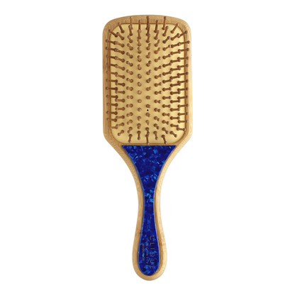 Back view of paddle hairbrush with bamboo body, bamboo bristles, and dark blue marble handle detail.