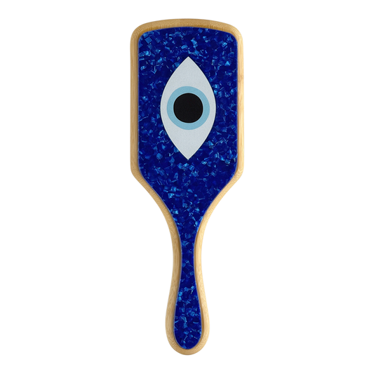 Front view of paddle hairbrush with bamboo body and dark blue marble design featuring a centered evil eye graphic.