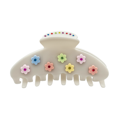 Off-white claw clip with pastel flower accents and multicolor rhinestone centers on the front.