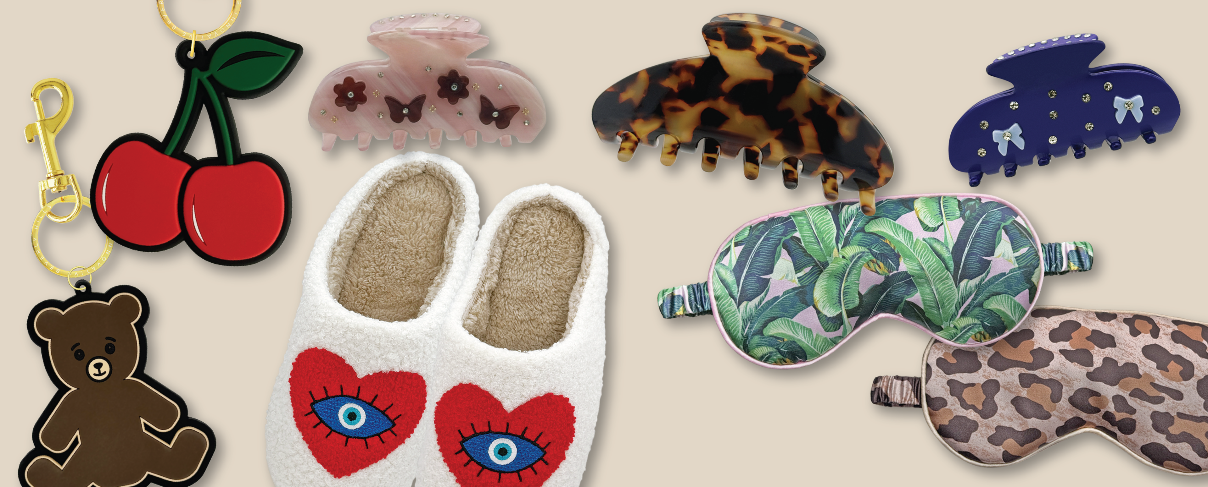 Collection of Clique Innovative Beverly Hills accessories including keychains, slippers, claw clips, and eye masks on a beige background.