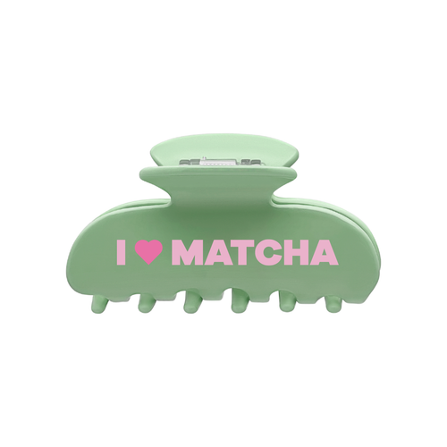 Front view of a green claw clip with the words “I”, a pink heart-shaped icon, and “MATCHA” printed across the front on a white background.