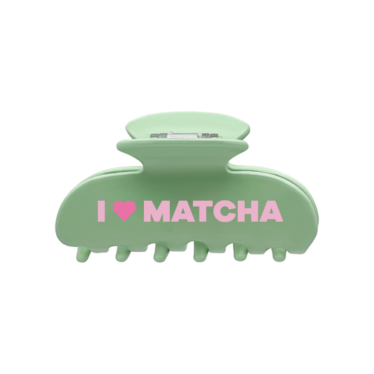 Front view of a green claw clip with the words “I”, a pink heart-shaped icon, and “MATCHA” printed across the front on a white background.