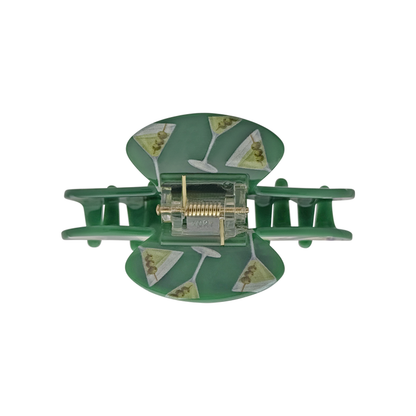 Top view of a green claw clip with martini glass pattern on a white background.