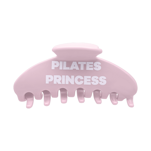 Front view of a pink claw clip with white Pilates Princess lettering.