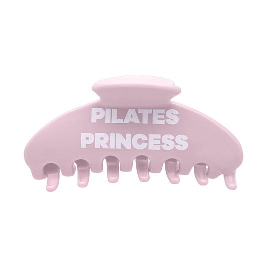 Front view of a pink claw clip with white Pilates Princess lettering.