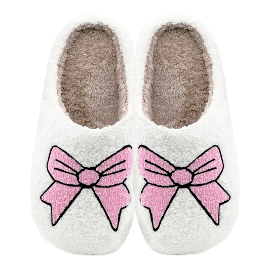 Pair of plush slippers with large pink bow design on the front.
