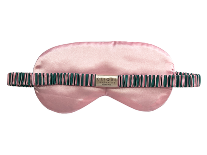 Back view of the pink, green, and white striped satin eye mask showing the elastic strap.