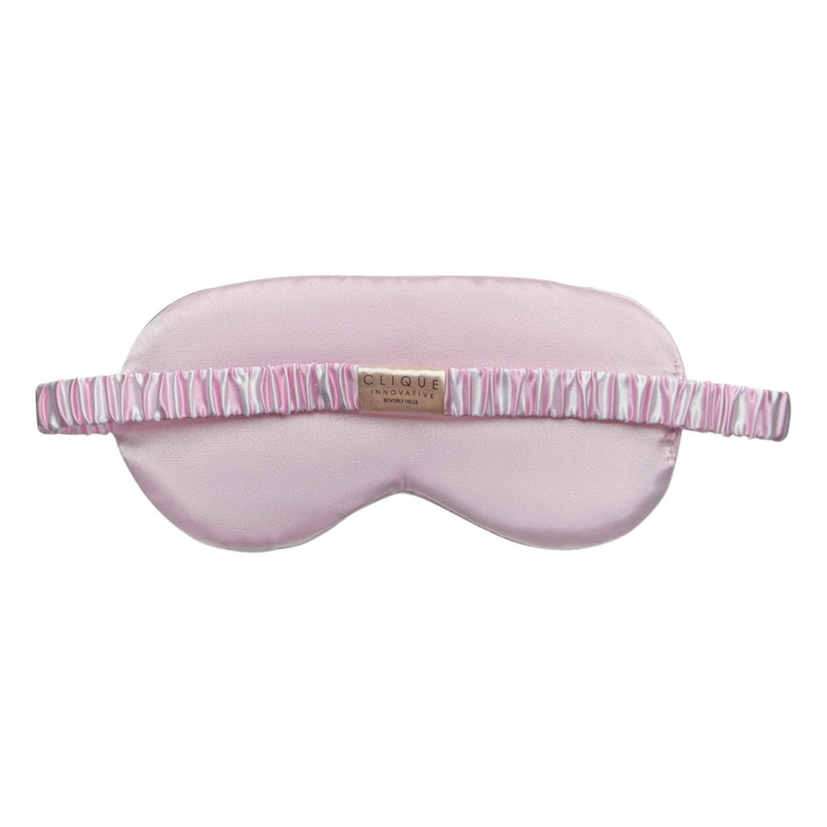 Back view of a light pink satin sleep eye mask with a pink-and-white striped ruched elastic strap and a small ‘Clique Innovative Beverly Hills’ label, shown on a white background.