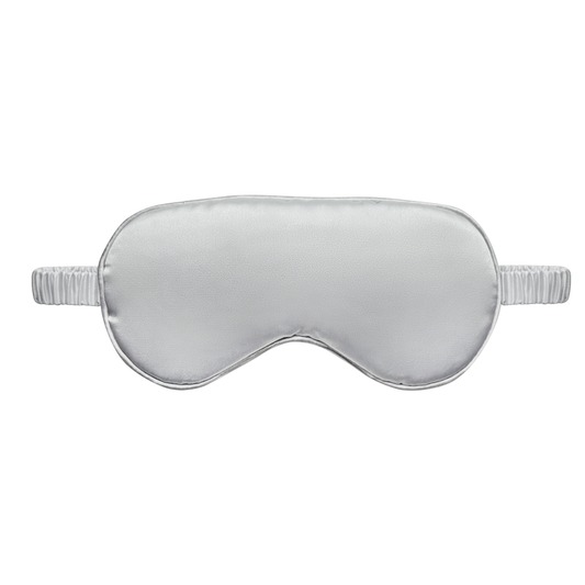 Front view  of a light silver satin sleep eye mask with an elastic ruched strap, shown on a white background.